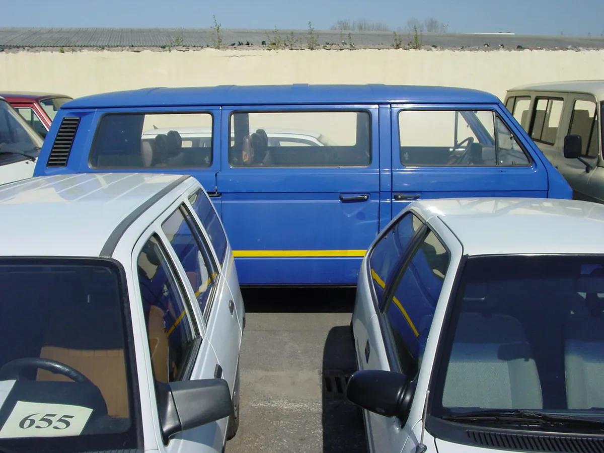 Coches usados aparcados con el precio y un número en el parabrisas